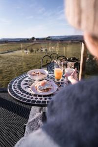uma mesa com pratos de comida e bebidas numa varanda em Eagles Nest Retreat em West Kentish