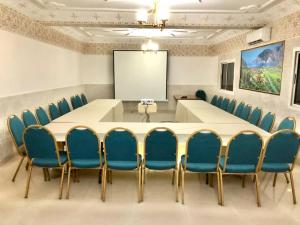 a conference room with a white table and blue chairs at kaizen Restaurant Nouakchott in Nouakchott