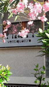 een bord aan de zijkant van een gebouw met roze bloemen bij Marcona24 in Milaan