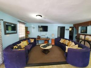 una sala de estar con sofás morados y una mesa. en Near Beach, Rivers, Lagoon, Spring, Sleep up to 22, 2nd Floor, en Vega Baja