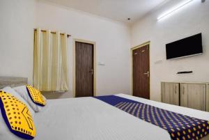 una camera da letto con un letto con cuscini gialli e blu di OYO Hotel Crown Plaza a Rudrapur