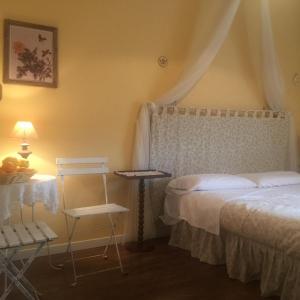 1 dormitorio con 1 cama, 1 silla y 1 mesa en B&B Xenia, en Mongiove