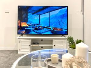 ein Wohnzimmer mit einem TV und einem Aquarium. in der Unterkunft Brand New Stylish 1BR Apartment, Specious Space, Free Parking, Self Check-in in Canberra