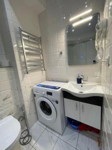 a bathroom with a washing machine and a sink at Brand new apartment near Gondola in Gudauri