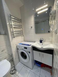 Un baño con lavadora y lavabo. en Brand new apartment near Gondola, en Gudauri