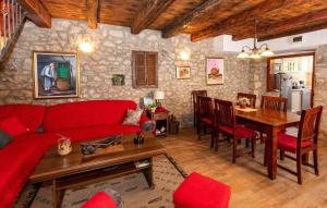 a living room with a red couch and a table at Rural house Janjić in Ploče