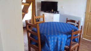 une table et des chaises avec une table bleue et une télévision dans l'établissement Maison d'Hôtes La Douloire, à Pernes-les-Fontaines