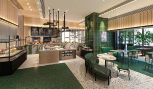 a restaurant with green tiles and tables and chairs at Artyzen Habitat Hengqin Zhuhai in Zhuhai
