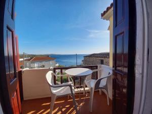 a balcony with a table and chairs and a view of the ocean at Evangelia Studios in Sígrion