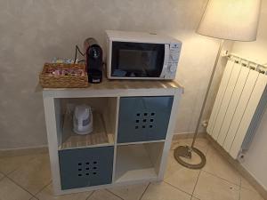 a microwave sitting on top of a stand with a table at Brunelleschi House with garden in Fiumicino