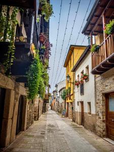 une rue vide dans une vieille ville avec des bâtiments dans l'établissement SEÑOR OSO, à Molinaseca