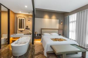 a hotel room with a bed and a bath tub at Horgos Golden International Hotel in Kurgash