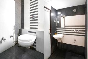 a bathroom with a toilet and a sink at FabHotel Shanti Sadan Near Ellisbridge in Ahmedabad