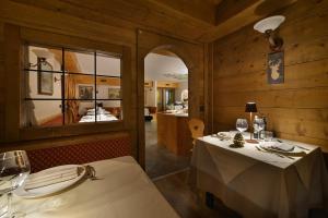 una sala da pranzo con 2 tavoli e uno specchio di Hotel Primula a Livigno