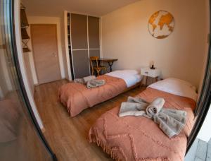 2 camas en una habitación con espejo en Le Reflet du Lac, en Sévrier