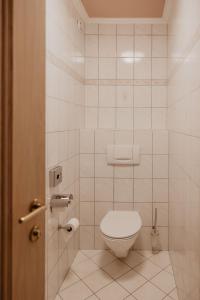 ein Bad mit WC in einem weiß gefliesten Zimmer in der Unterkunft Parkhotel Matrei in Matrei am Brenner