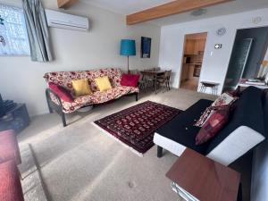 a living room with a couch and a table at Hop, Skip & Jump From Picton Waterfront in Picton