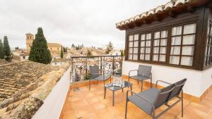 a balcony with chairs and a table on a building at Carmen San Luis Albaicin, Granada in Granada