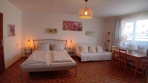 a bedroom with two beds and a table and a desk at Penzión Vilka Podhájčanka in Podhájska +88 photos