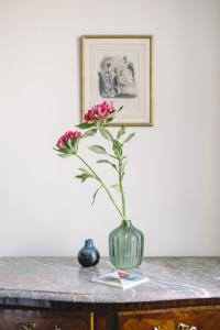 een vaas met een roze bloem erin op een tafel bij Le Château de l'Aile in Vevey