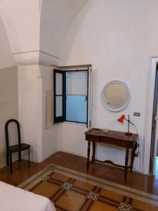 ルッファーノにあるAntica Via delle Aieのテーブルと鏡付きの部屋