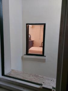 una ventana en una pared blanca con una silla. en Antica Via delle Aie, en Ruffano