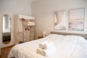 Un dormitorio con una cama blanca con toallas. en Panagiotidis lake house, en Kastoria