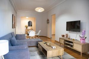 a living room with a blue couch and a tv at Panagiotidis lake house in Kastoria