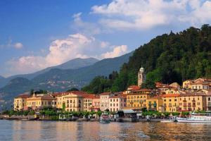 a group of buildings on the water with mountains at Bellagio Spiaggia due in Bellagio