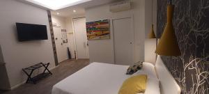 een kamer met een wit bed en een televisie bij Marcona24 in Milaan