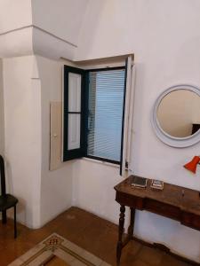 Cette chambre comprend un miroir et une table en bois. dans l'établissement Antica Via delle Aie, à Ruffano