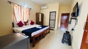 a bedroom with a bed and a television in it at HARSH ANGEL HOLIDAY HOMES in Calangute