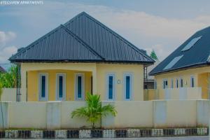 a yellow house with a black roof at Tegsview Apartments, Ughelli in Ughelli