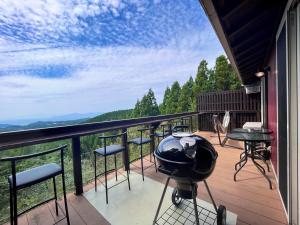 a grill on a balcony with a view of the mountains at Yuushin in Mifune