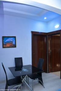 a dining room with a black table and chairs at Tegsview Apartments, Ughelli in Ughelli