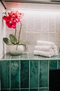 a vase with a flower on a shelf with towels at Boutique Grade II Listed Gem, City centre, Fast WiFi, Family/ contractors in Birmingham