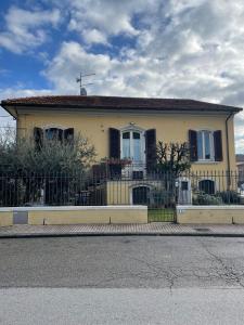 uma casa amarela com uma cerca em frente em Appartamento in the Heart of Tuscany em Monsummano
