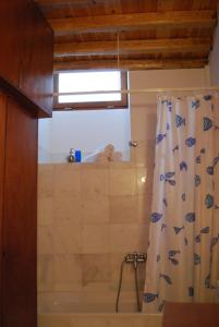 a bathroom with a tub and a shower curtain at Stone Mansion House in Skopelos Town
