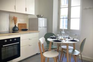 une cuisine avec une table et des chaises dans l'établissement Le Mario-Cosy appart au calme proche centre, à Nantes