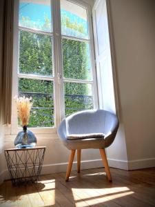une chaise bleue assise devant une fenêtre dans l'établissement Le Mario-Cosy appart au calme proche centre, à Nantes