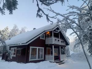 eine Hütte mit Schnee auf dem Dach im Schnee in der Unterkunft Levi Piippo 2 in Kittilä