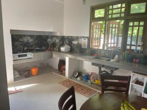 cocina con encimera y mesa con sillas en Shenumi villa en Waskaduwa