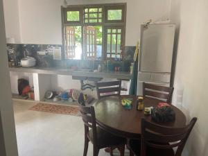 cocina con mesa, sillas y nevera en Shenumi villa en Waskaduwa