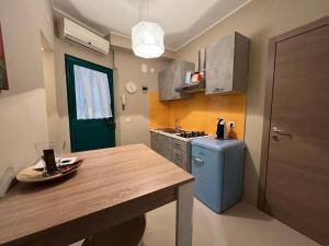 a small kitchen with a blue refrigerator and a table at Tavernetta Cortile Dalmazia in Catania