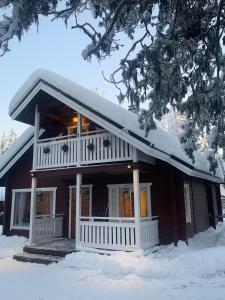 ein Holzhaus mit Schnee auf dem Dach in der Unterkunft Levi Piippo 2 in Kittilä