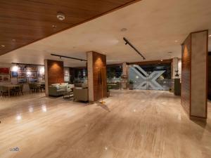 Luxo Kochi في إرناكولام: غرفة كبيرة مع أرضية خشبية وغرفة معيشة