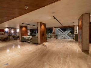 a large room with a wooden floor and a living room at Luxo Kochi in Ernakulam +32 photos