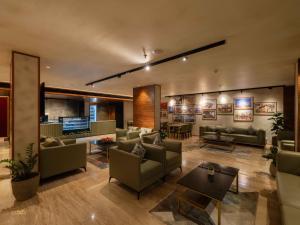 uma sala de estar com sofás e mesas e um átrio em Luxo Kochi em Ernakulam