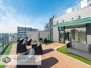 a rooftop patio with black furniture on a building at Astil Hotel Juso Precious - Vacation STAY 16039v in Osaka