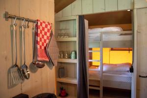 a kitchen with a bunk bed with utensils at Luxe Safaritent 6 persoons op Camping Rijsterbos in Rijs